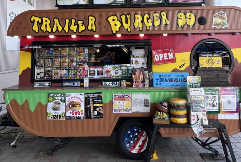 TRAILER BURGER 99　トレーラーバーガー99　キッチンカー　大型キッチントレーラー　移動販売　開業1周年　オープン以来、新鮮　十勝産食材　十勝産　北海道産　安心　安全　長いも　グルーンアスパラ　野菜類　マッシュルーム　チーズ　牛肉　北海道産小麦 100%バンズ　クラフトバーガー　提案　限定商品　人気　ハンバーガー　帯広市　十勝管内　新得町　幕別町　プレゼント　特典　TRAILER BURGER 99　トレーラーバーガー99　キッチンカー　大型キッチントレーラー　移動販売　開業1周年　オープン以来、新鮮　十勝産食材　十勝産　北海道産　安心　安全　長いも　グルーンアスパラ　野菜類　マッシュルーム　チーズ　牛肉　北海道産小麦 100%バンズ　クラフトバーガー　提案　限定商品　人気　ハンバーガー　帯広市　十勝管内　新得町　幕別町　マグプラネット　2024年6月　メムロピーナッツ　メムピー　メムピーナッツバターメープルクリームチーズベーコンバーガー　新顔作物　落花生　にんにく　さつまいもをPRする企画　とかちの農業推し勝プロジェクト　十勝ハーブ牛　イトーヨーカドー帯広　トレバガベース　新規オープン　オープン　グランドオープン　開店　新規開店　OPEN　2024年9月9日（月）11時　〒089-0538 北海道中川郡幕別町札内共栄町１６−４　インデアン 札内店　みずほ通り歯科クリニック　美味館　メニュー　場所　イートイン　テイクアウト　駐車場　国道38号線　北海道　幕別町　札内