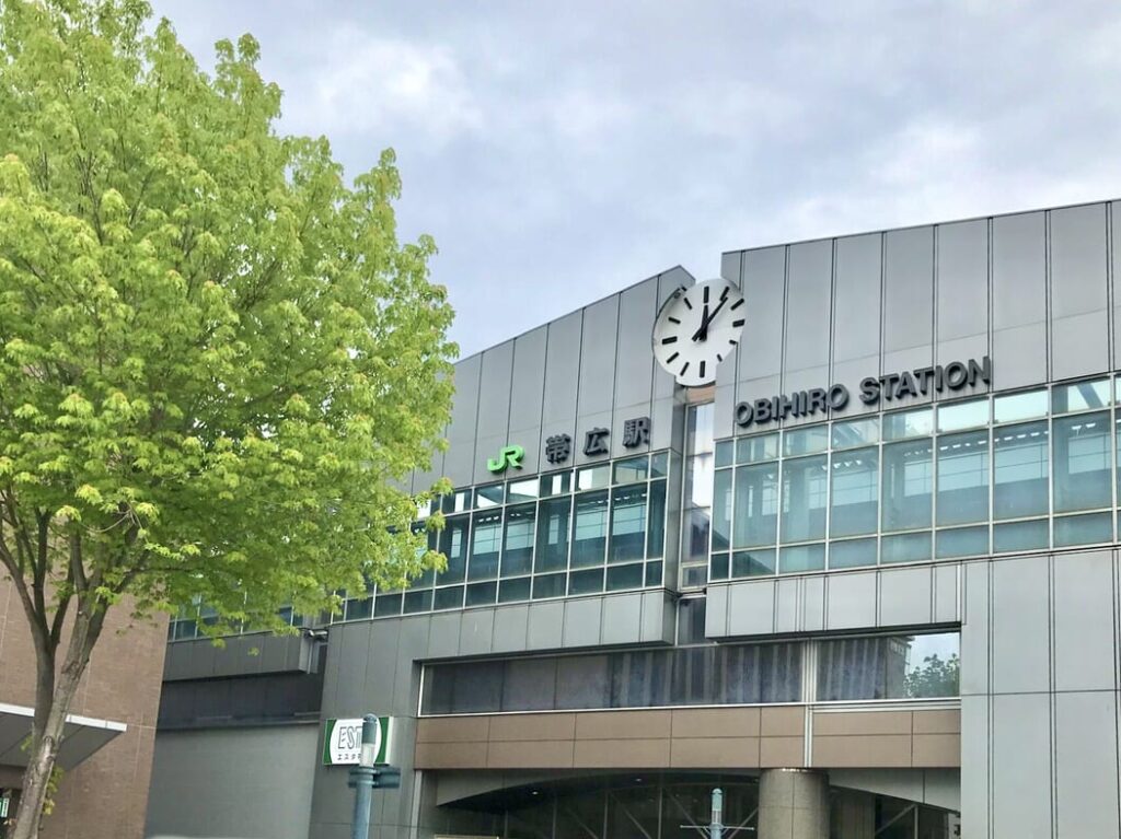 2026年10月に新規オープンを予定している「赤から帯広店」（〒080-0015 北海道帯広市西5条南19丁目7番地）の開店前の外観写真。お店は西5条通沿いに位置し、近くには「森のスパリゾート 北海道ホテル」があり、JR帯広駅からも車で約3分とアクセスしやすい好立地。写真に写る建物には、名物の旨辛な「赤から鍋」や独自ブレンドの味噌グルメを象徴するお馴染みの赤い看板はまだこれから設置される段階のため掲げられておらず、新店舗の誕生に向けて準備が進められている状態の静かな店構え。オープン　新規オープン　新規開店　開店　新店舗　帯広グルメ　赤から　帯広初出店　帯広初上陸　帯広初　掛村　かけむら　KAKEMURA　閉店　十勝Chinese 十勝帯広創作料理灯火（とうか）の移転リニューアルオープン告知画像。新店舗の郵便番号は〒080-0012、住所は北海道帯広市西2条南10丁目14-1 HEIGENハートフルビル地下1階（B1F）。帯広駅から徒歩約4分の好立地。移転前の旧住所は〒080-2473 北海道帯広市西23条南1丁目7番。移転リニューアルオープン日は2026年6月15日月曜日。十勝産牛、炭火焼き、海鮮料理をメインとする創作居酒屋。営業時間は、事前予約制のランチが月曜日から金曜日の11時から14時。ディナーは月曜日から木曜日が18時から24時、金曜日・土曜日・祝前日が18時から翌朝28時（翌4時）まで営業。ラストオーダーは各閉店時間の30分前。定休日は日曜日と祝日（祝前日を除く）。電話番号は0155-66-8531。予約は電話または公式Instagram（インスタグラム）のダイレクトメッセージ（DM）にて受付。