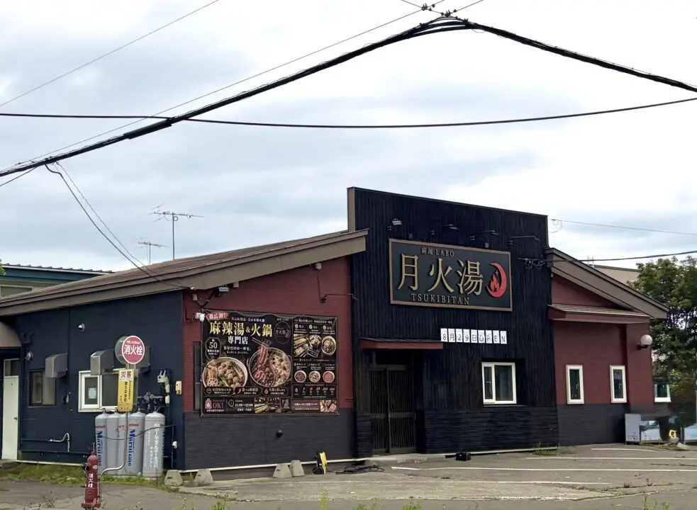 2026年8月29日(土曜日)にグランドオープンを迎える、本格シビ辛料理の専門店「麻辣LABO 月火湯(まーらーらぼ つきびたん)」の新規開店告知ビジュアル。店舗の所在地は「〒080-0051 北海道帯広市白樺16条西11丁目」で、地元で親しまれていた「元 麺屋弐式」の跡地。お店の最大の特徴である2つの営業スタイルを詳しく紹介しており、ランチタイム(営業時間 11:00〜14:15最終入店)は「昼は自分で選ぶ麻辣湯」として、好みの具材や辛さをカスタマイズして1人で気軽に楽しめるセルフスタイルの麻辣湯を提供。ディナータイム(営業時間 17:30〜21:15最終入店)は「夜はみんなで囲む火鍋」として、複数人で本格的なシビ辛スープを堪能できる火鍋専門店へと変わる。会計時の決済方法は、各種クレジットカードをはじめ、PayPayなどのQRコード決済、各種交通系電子マネーに幅広く対応している。公式Instagramアカウント(@tsukibitan)の案内とともに、背景には真っ赤なスープにスパイスが効いた、食欲をそそる本格的な麻辣湯と火鍋の料理イメージ写真が大きく掲載されている。
