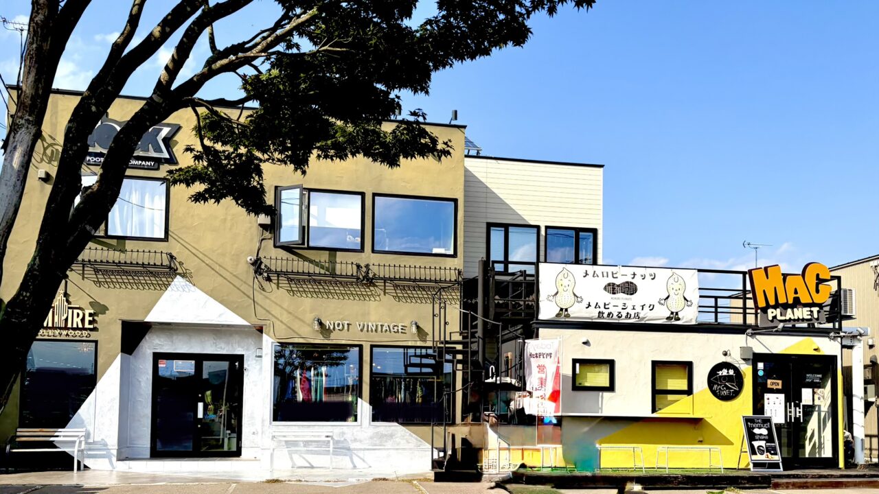 マグプラネット タピオカ専門店 住所は 〒082-0803 北海道河西郡芽室町東めむろ3条北1丁目1−4 愛菜屋 インデアン芽室店 駐車場あり 2029年6月24日に閉店する マグプラネットの外観はプレハブでできている 可愛らしいオレンジ色のロゴ看板も設置されている メムロピーナッツのメニューも表示されている 隣にはEMPIRE HOLLYWOOD 十勝本店 (芽室)というアパレル店がある EMPIRE HOLLYWOOD 十勝本店 (芽室)というアパレル店の外観も写っている