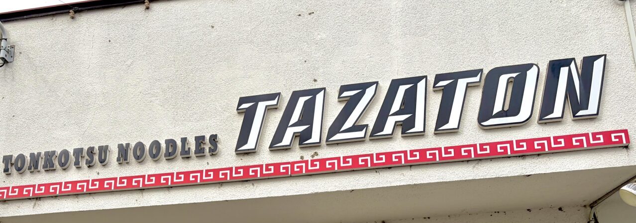 トンコツ ヌードルズ TAZATON 帯広のラーメン店 豚骨ラーメンが人気 住所は〒080-0050 北海道帯広市白樺16条東7丁目6−6 敷地内に駐車場もあるので車でも安心 写真は店舗外の看板 看板にはTONKOTSU NOODLES TAZATONと記載されている