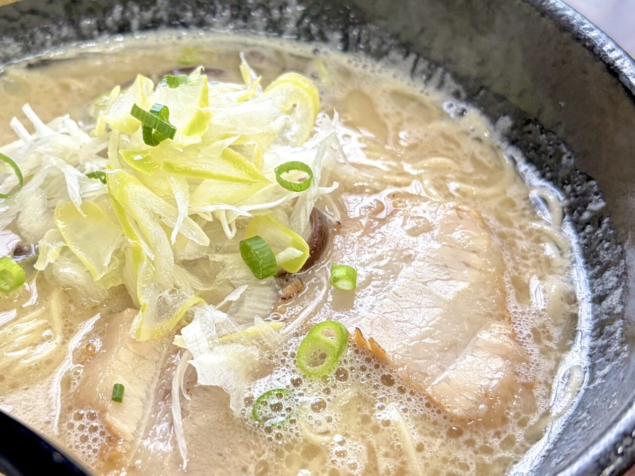 トンコツ ヌードルズ TAZATON　帯広のラーメン店　豚骨ラーメンが人気　住所は〒080-0050 北海道帯広市白樺１６条東７丁目６−６　敷地内に駐車場もあるので車でも安心　写真は20時間以上焚き出した豚骨スープ使用の豚骨ラーメン　チャーシューやネギとの相性も抜群　濃厚でクリーミーはスープが絡む　細麺
