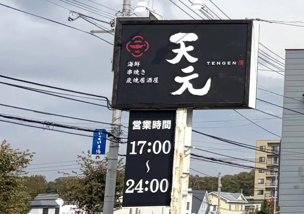 海鮮・串焼き居酒屋 天元 〒080-0027 北海道帯広市西１７条南３丁目２２−１５ キコロハイツ　2026年9月10日グランドオープン　天元の黒い看板と営業時間　青空に映える看板に天元と白い文字が書かれている　グランドオープン　新規オープン　オープン　新規開店　開店　帯広グルメ　帯広居酒屋